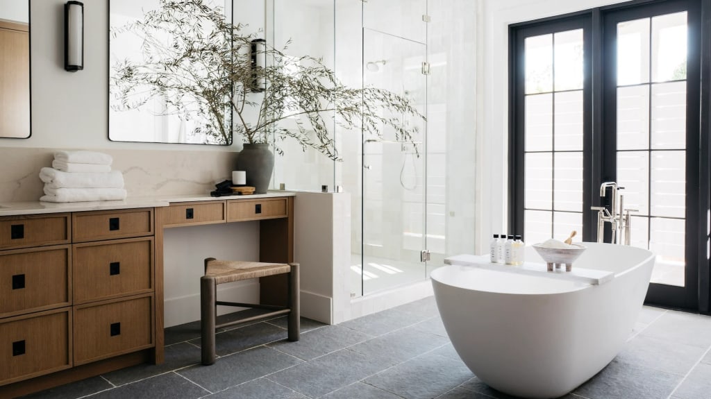 Trendy bathroom with white bathtub and wooden furniture
