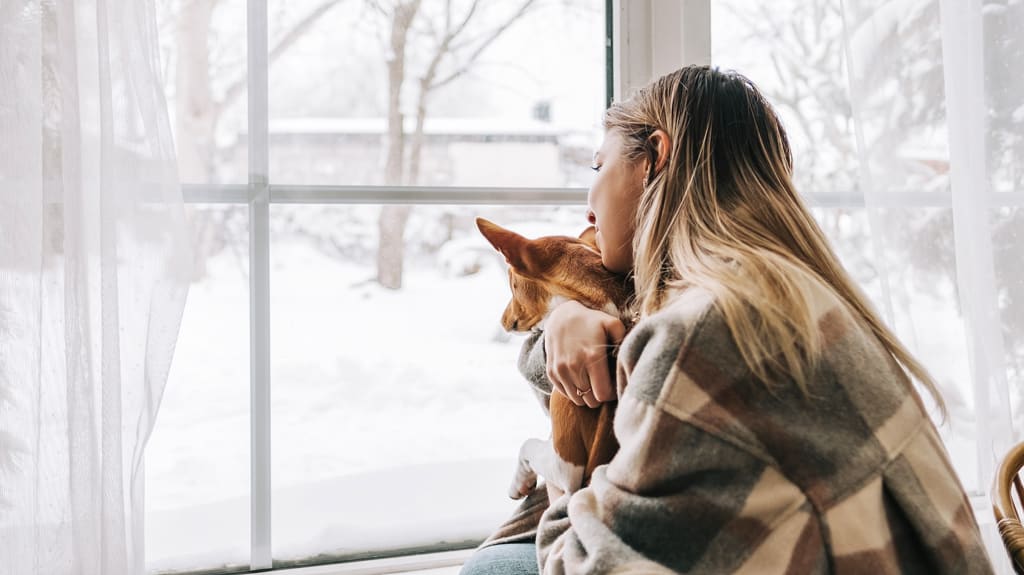 Propriétaire qui regarde à l’extérieur en songeant à préparer sa maison pour l’hiver