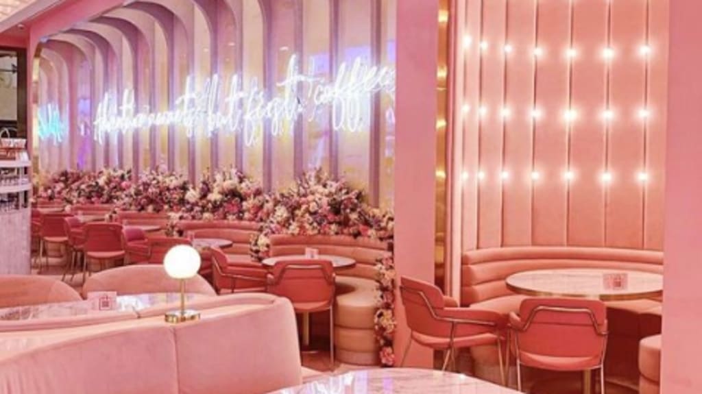 restaurant rose maximaliste avec décorations roses et panneau lumineu