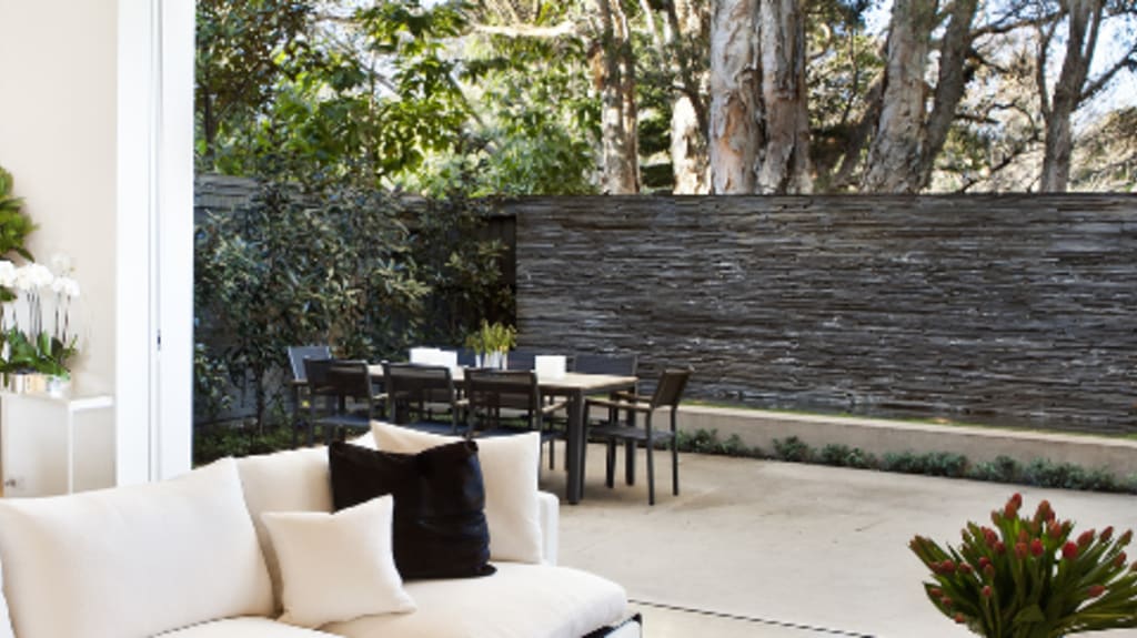 Large living room with white couches and large glass patio door leading to backyard