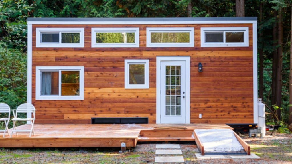 wooden tiny home with patio in forest