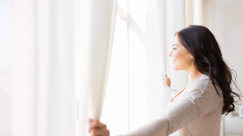 Femme regarde à travers une fenêtre d'aluminium