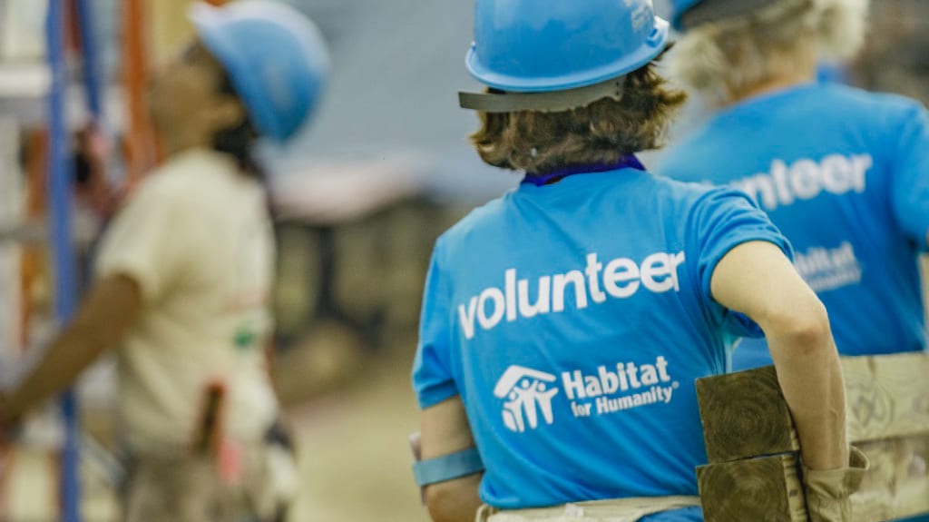 benevoles transportant des matériaux de construction sur un chantier de Habitat pour l'humanité