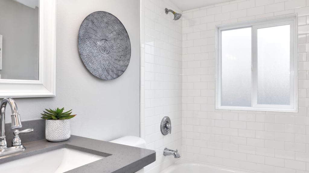 salle de bain avec bain douche blanc et comptoir gris foncé