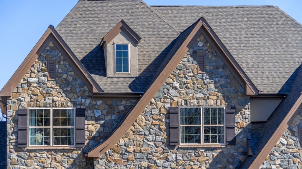 Fieldstone house with three gables and asphalt shingle roof