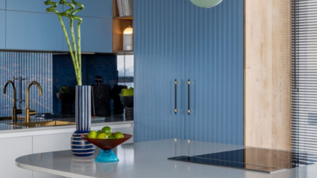 ilot de cuisine bleue avec comptoir blanc et armoires bleues