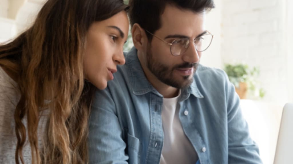 couple calculating cost on computer