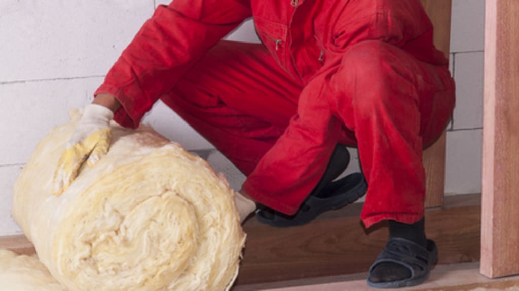 worker insulating a house attic