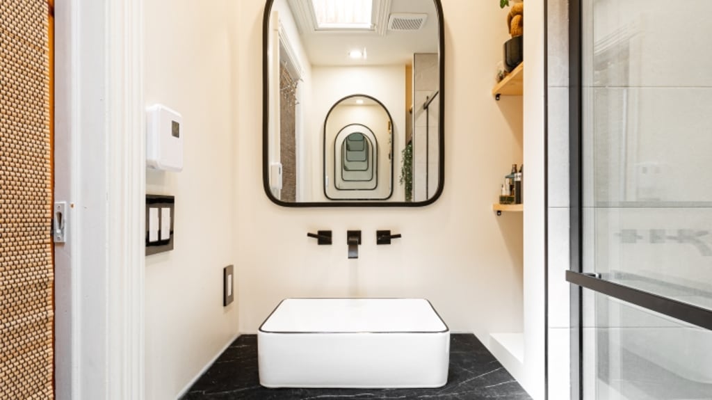 Contemporary white bathroom with view of mirror and white sink.