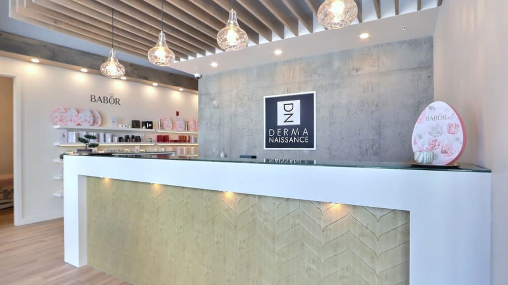 The front foyer of Dermanaissance incorporates beauty salon design features like a white desk with wood panelling, bright pendant lights, and pink accents