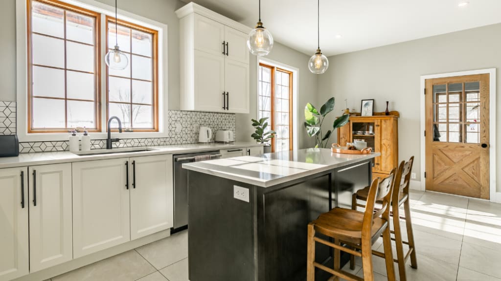 A modern rustic house renovation featuring a kitchen with white cabinets and a black island