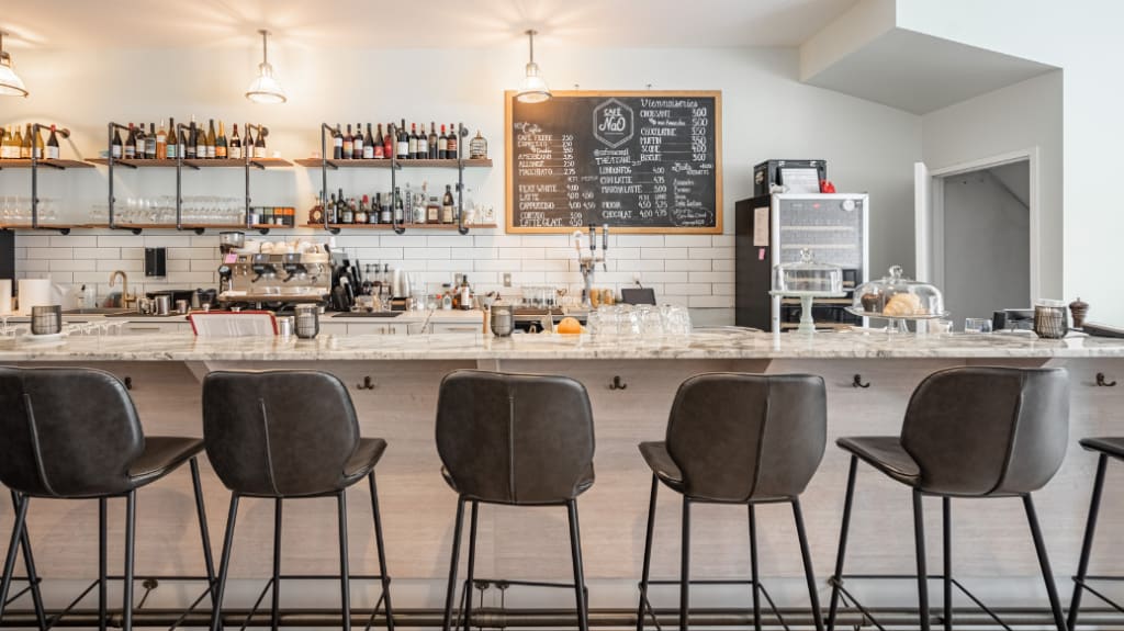 Bar dans un restaurant avec chaises hautes en cuir et bouteilles d