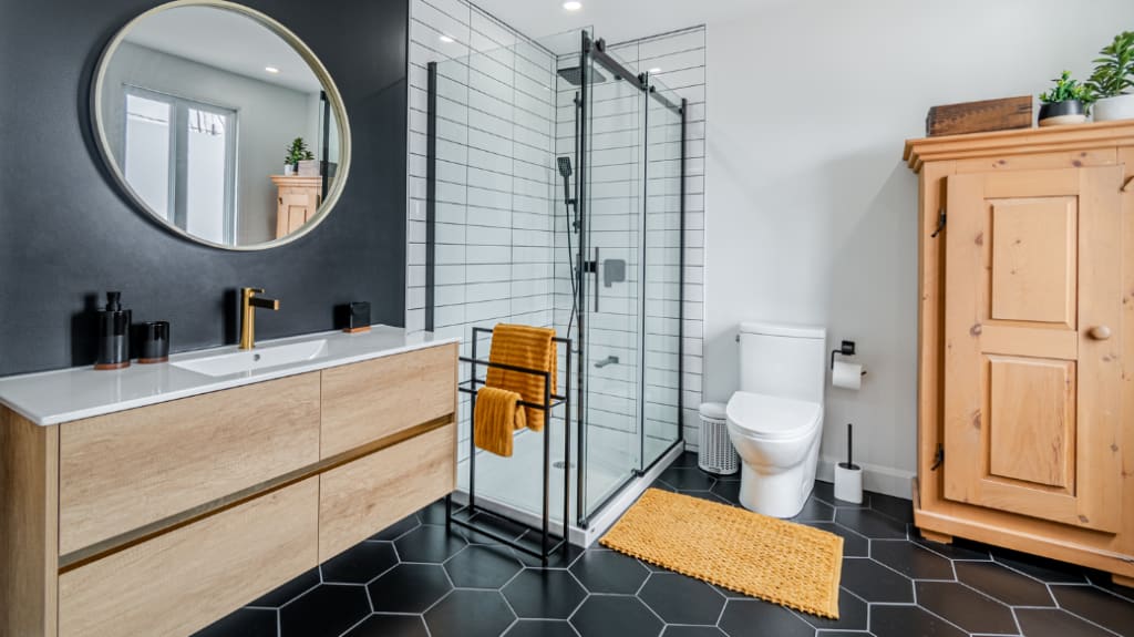 Salle de bain noire contemporaine avec meuble-lavabo en bois, miroir rond et douche à l