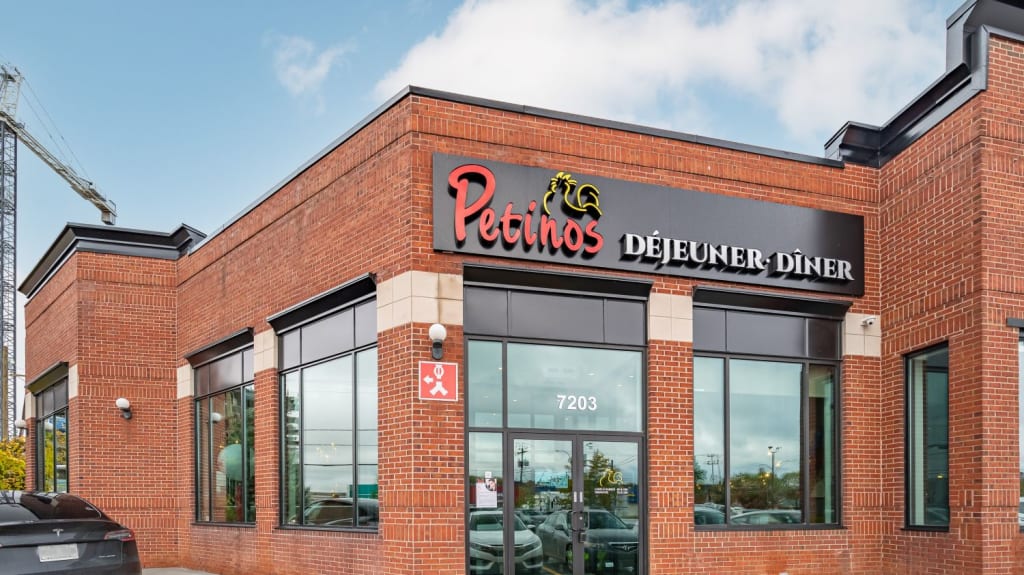 A red brick exterior featuring a large sign for Petinos restaurant