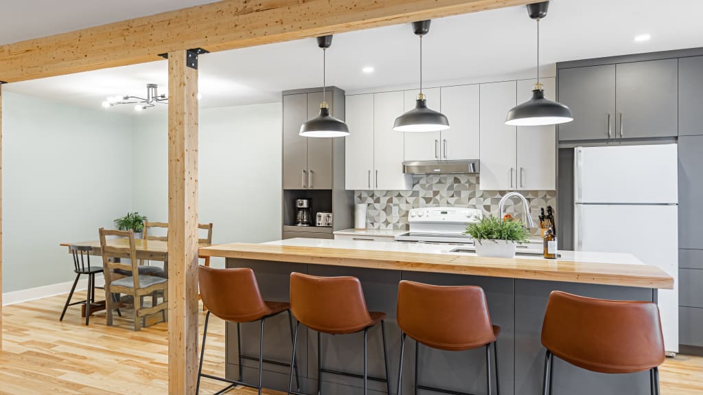 open space kitchen with a big island and wooden beams