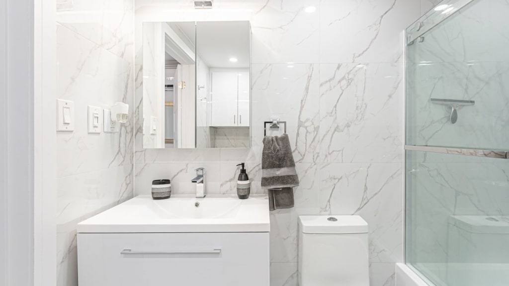 A modern bathroom renovation with a white sink and toilet