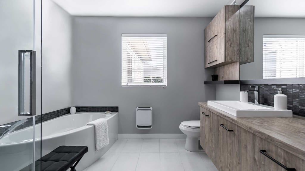 renovated bathroom with corner bathtub, glass shower and wooden cabinets