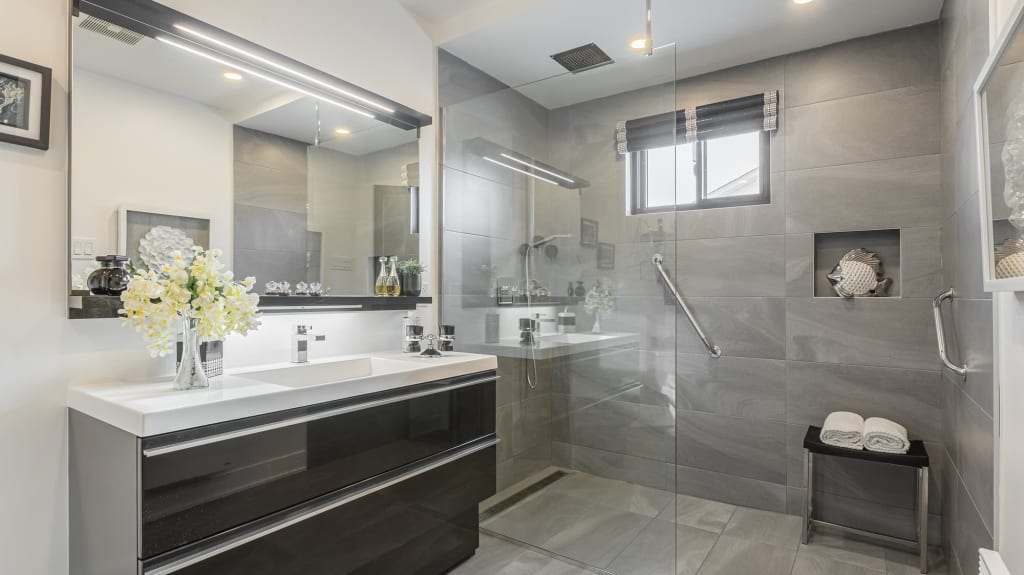 grey bathroom with walk-in shower and black vanity