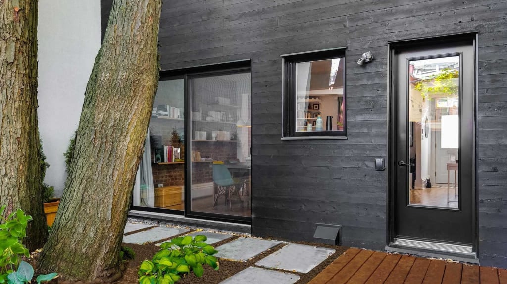 revêtement extérieur en bois noir derrière maison urbaine