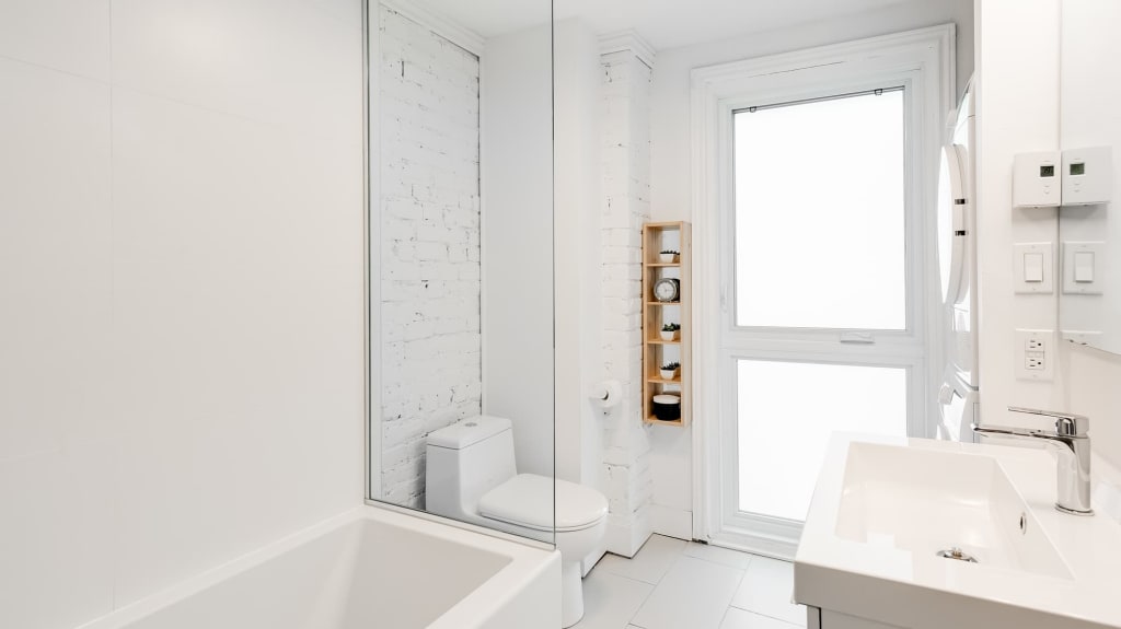 rénovation de salle de bain blanche avec mur en brique blanc