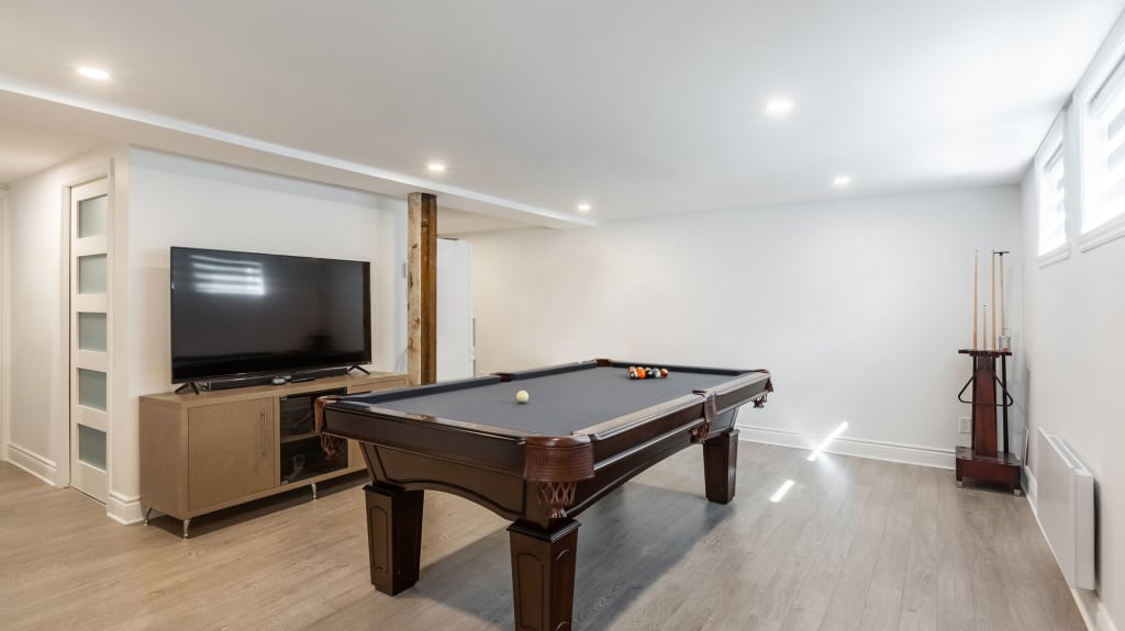 rénovation de sous-sol avec table de billard et téléviseur