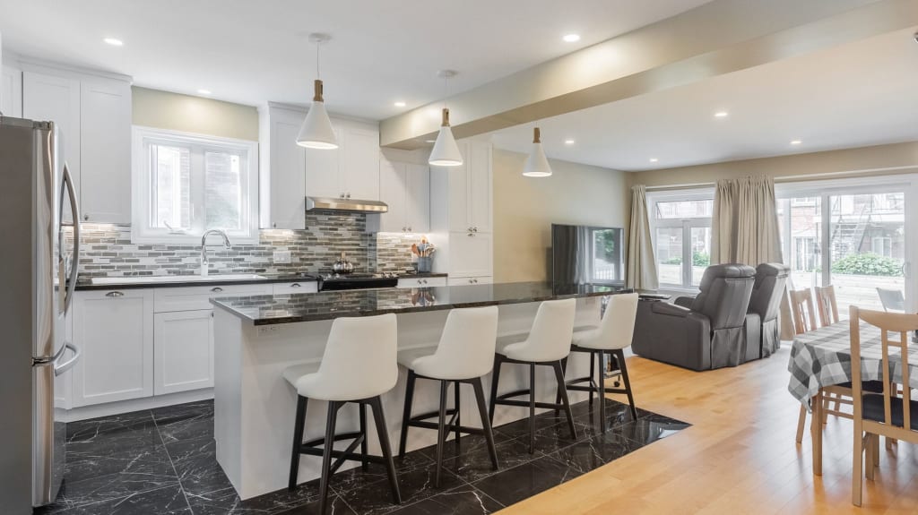 modern kitchen with white cabinets and black countertops