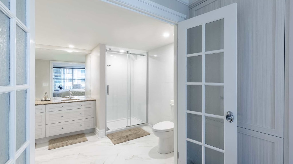 rénovation de salle de bain avec vanité blanche et douche vitrée