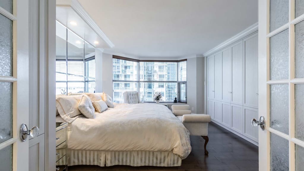 chambre des maîtres avec mobilier sur mesure et portes vitrées