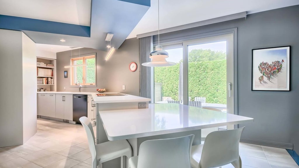 cuisine moderne en mélamine blanche avec table repas intégrée au comptoir