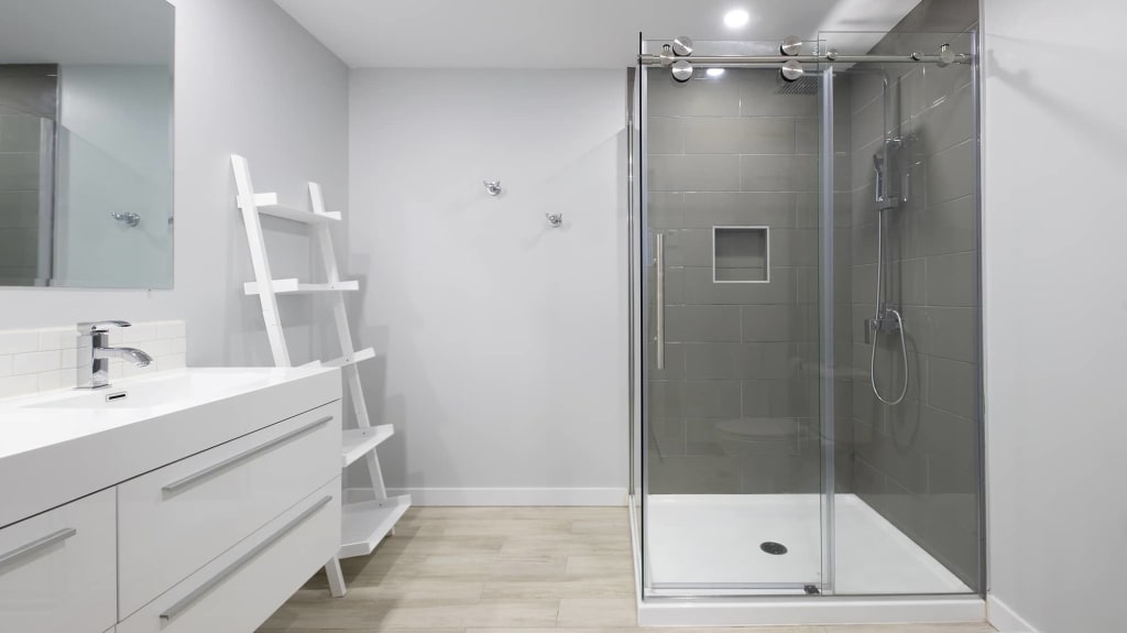 New bathroom in a basement with a shower and a white vanity