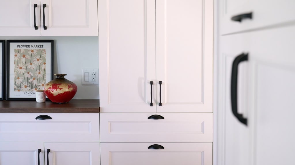 White kitchen cabinets with black handles