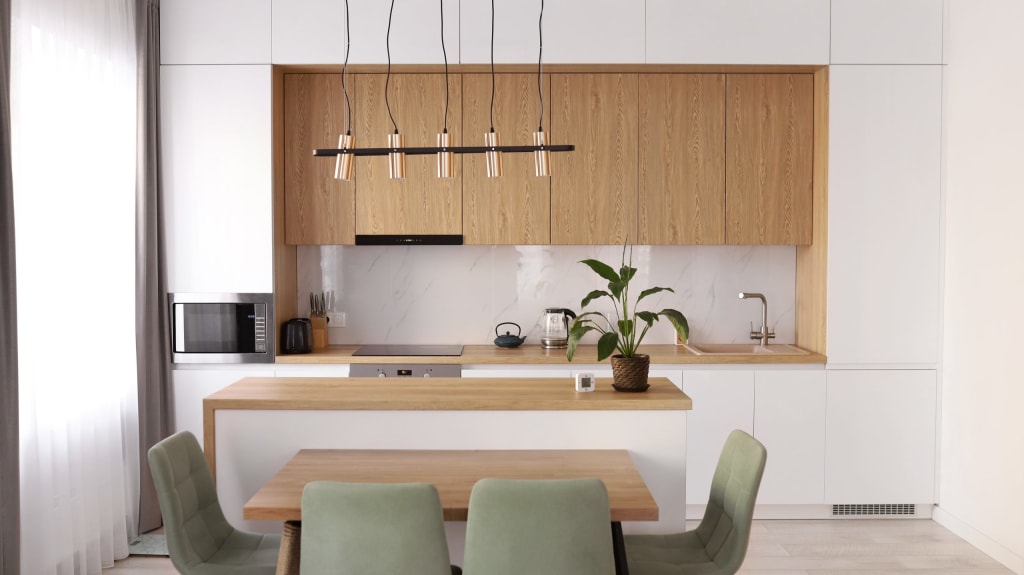 Modern Scandinavian kitchen with white cabinets, wood accents and dining area