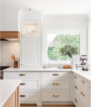 Countertop storage hutch in a kitchen with white cabinets and gold handles