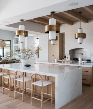 Two large marble islands in a beige and white kitchen