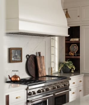 Large white hood, stainless steel stove, wooden accessories and copper teapot