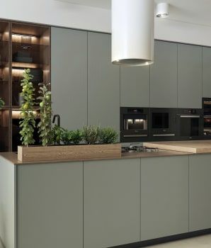 Olive-green kitchen with white hood and herb plants