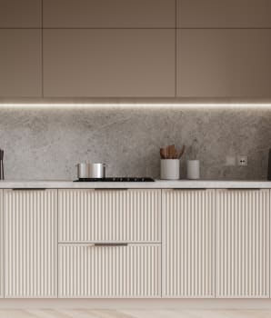Beige textured cabinets and drawers in a kitchen with gray backsplash