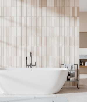 Baignoire devant un mur de carrelage vertical beige
