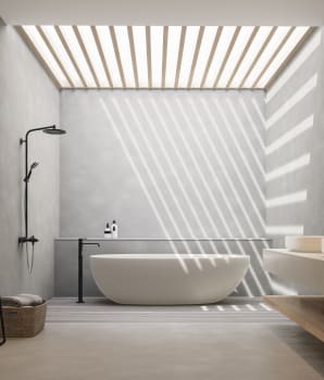 Mur et sol en béton dans une salle de bain avec plafond qui laisse entrer la lumière