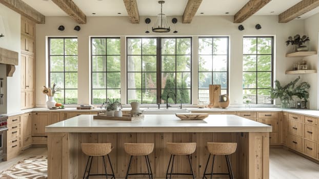 Interior of a farmhouse kitchen in a French country house with wooden cabinets, white marble countertops and rattan benches