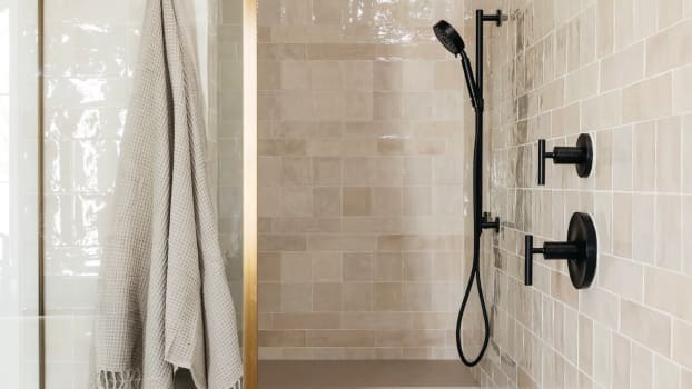 Carrelage beige sur le sol et le mur d’une douche à la robinetterie noire