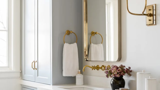Armoires et tiroirs de salle de bain bleu gris avec poignées, miroir et accents métalliques dorés 