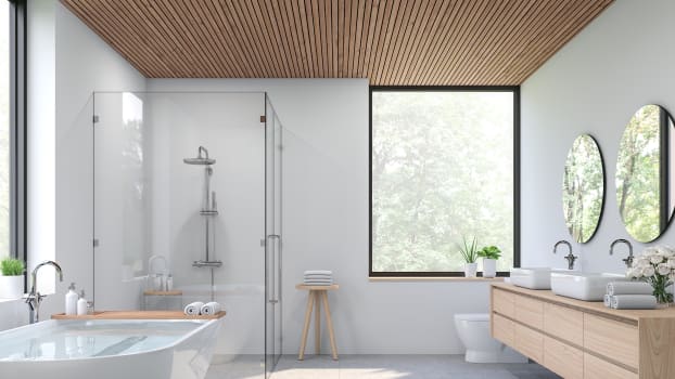 Plafond en bois, sol en carrelage de béton et murs blancs dans une salle de bain