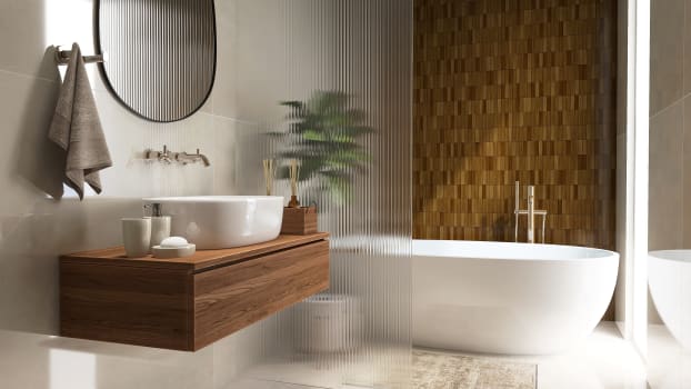 Bain, cloison en verre, mur en carrelage marron, lavabo et accessoires
