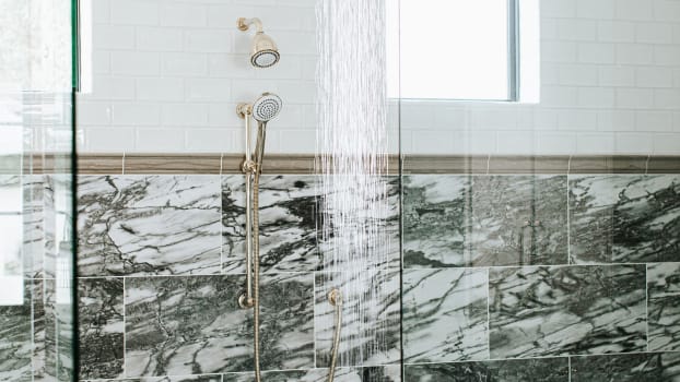 Mélange de tuiles dans des teintes de vert à même la douche derrière une porte vitrée