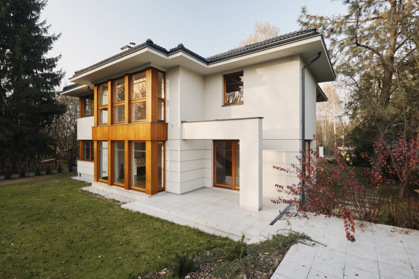 Front of a Scandinavian-style white house with wood accents