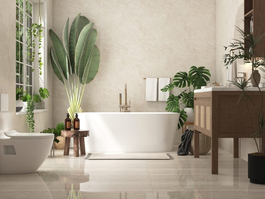 Décoration intérieure d’une salle de bain lumineuse avec plantes et carrelage beige en marbre