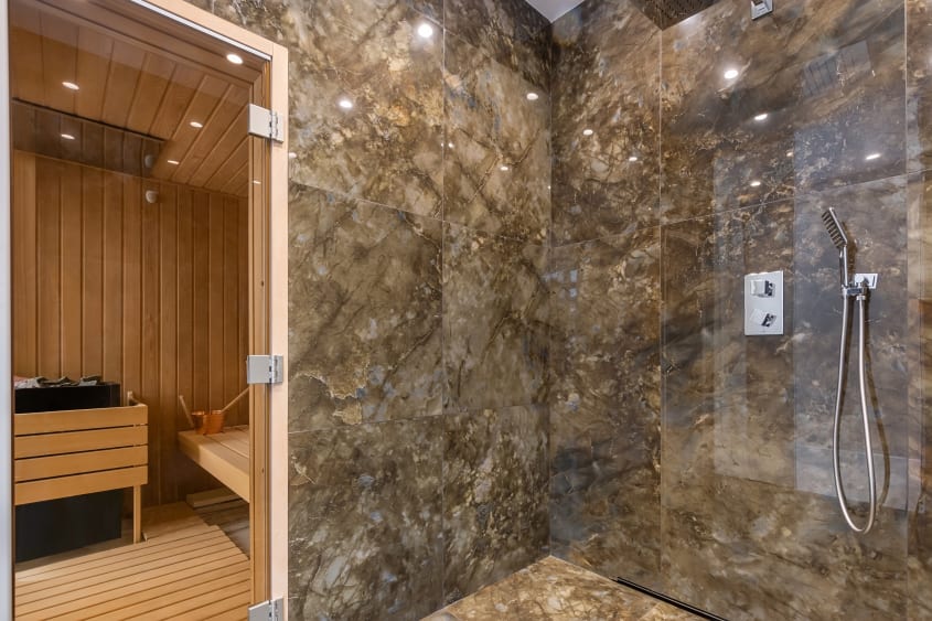 Douche en pierre adjacente à un sauna