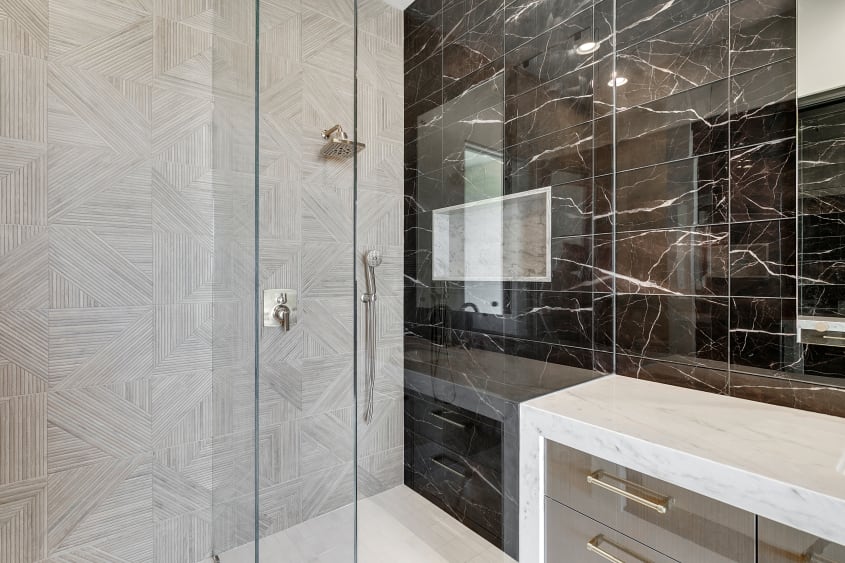 Pommeau de douche fixe en acier inoxydable et mur de céramique noire avec veinures blanches
