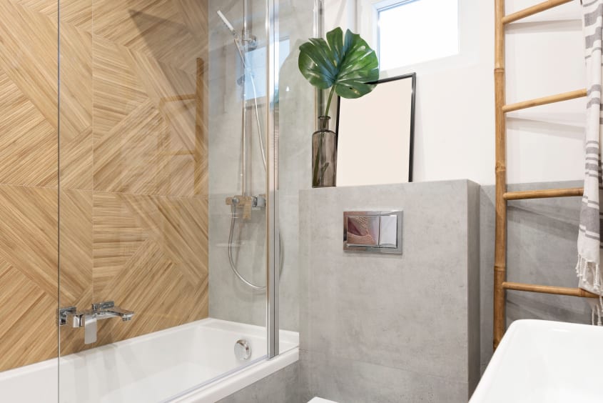 Bain intégré dans une douche, mur de bois et échelle décorative dans une salle de bain